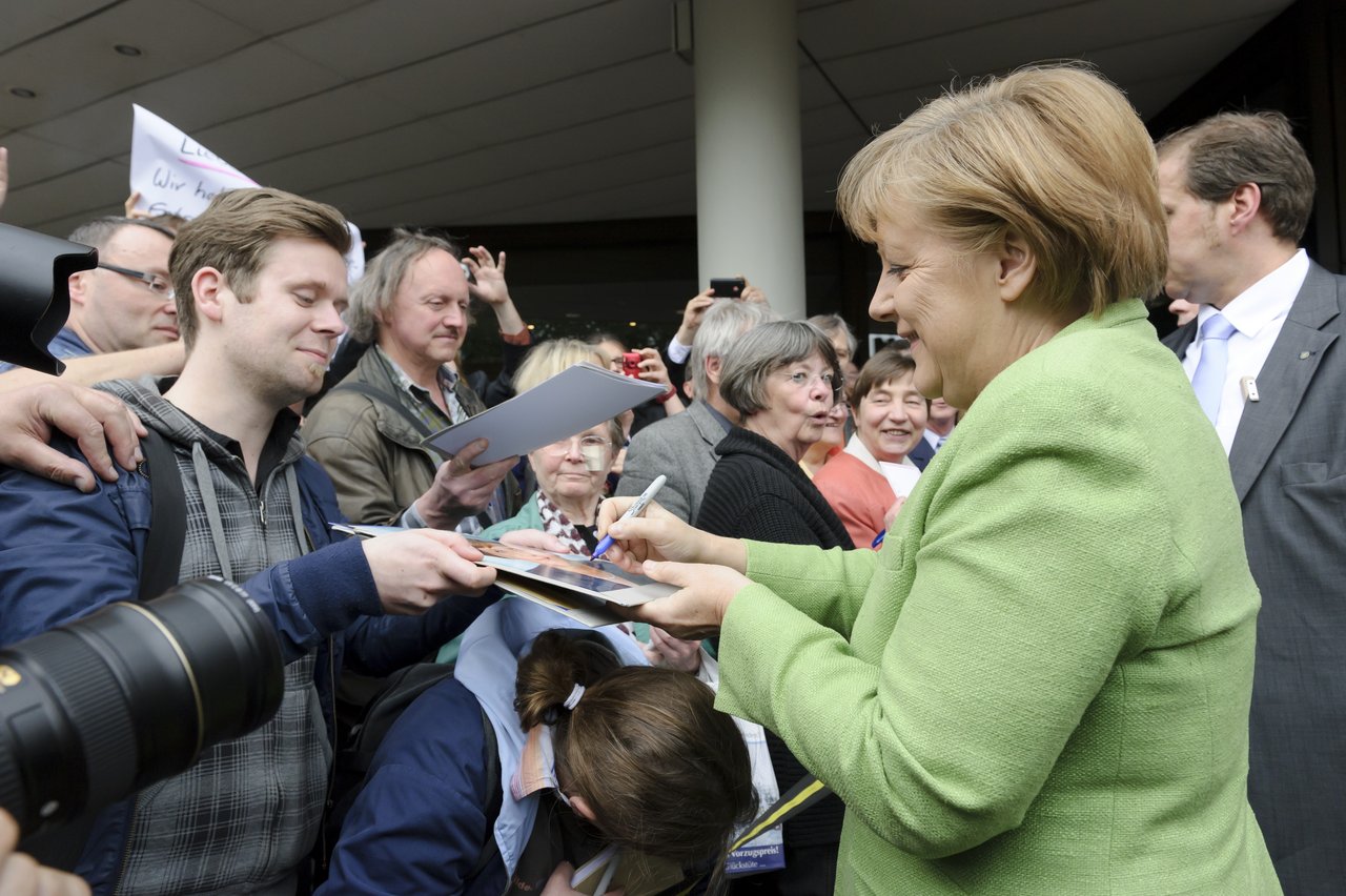 Chancellor Dr. Angela Merkel giving autographs.