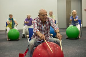 Man drumming on an exercise ball