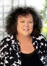 Porträtfoto der BAGSO-Vorsitzenden Dr. Regina Görner: ältere Frau mit dunklen kinnlangen lockigen Haaren und schwarz-weißer Bluse. 
