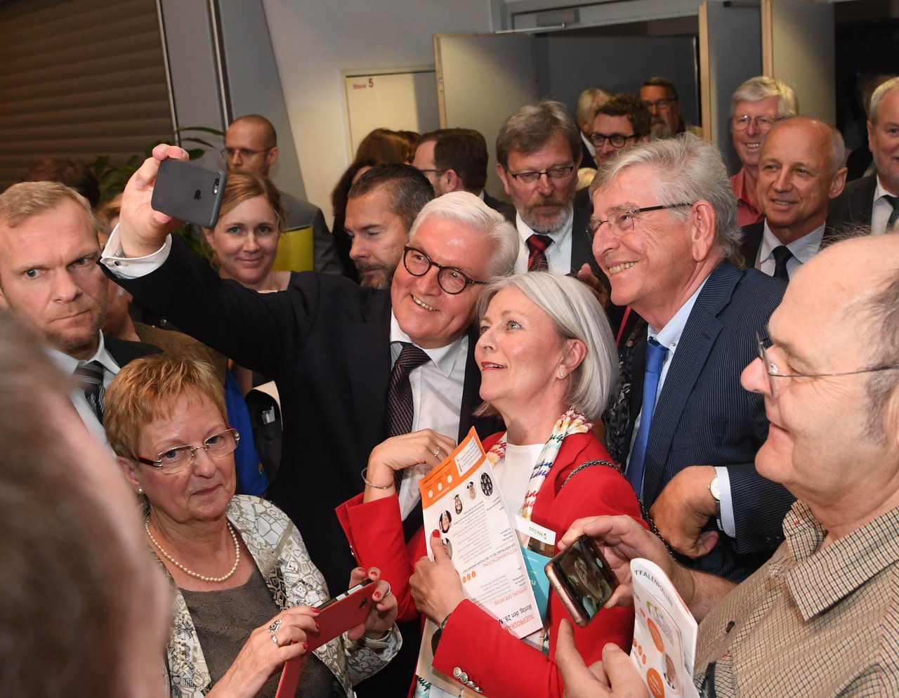 Bundespräsident Steinmeier macht Selfie mit einer Frau in Menschenmenge