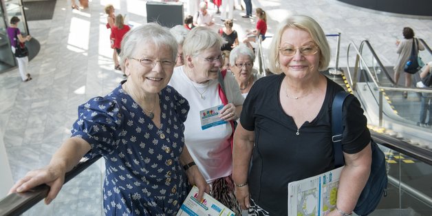 Besucherinnen auf der Rolltreppe im Eingang einer Messehalle.