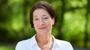 ©Ulrike Frömel Portraitfoto Judith Prem: eine Frau mit braunen kurzen Haaren trägt Perlenohrringe und eine Bluse.