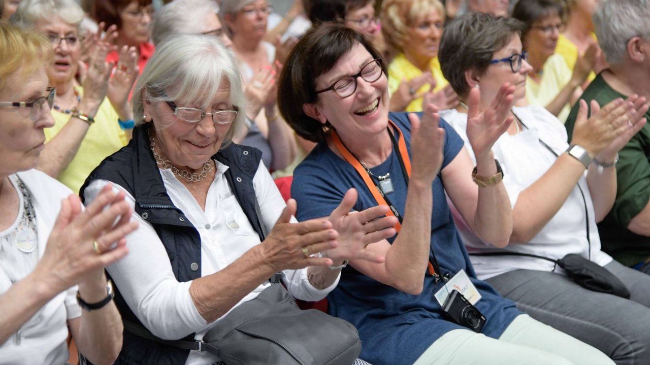 Frauen im Publikum klatschen lachend.