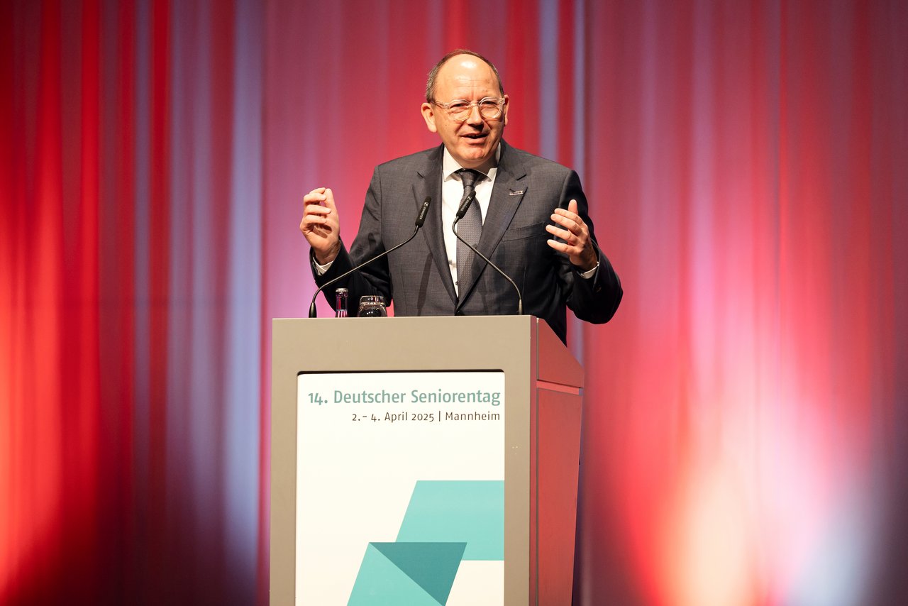 Oberbürgermeister Christian Specht, eine älterer Mann mit Halbglatze. Er trägt eine Brille und hat einen braunen Anzug mit Schlips an. Er steht am Rednerpult und hält einen Vortrag. Klick öffnet eine vergrößerte Ansicht.