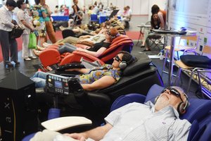 Visitors lying on armchairs wearing dark glasses and headphones