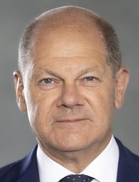 Porträtfoto des Bundeskanzlers Olaf Scholz: Ein älterer Mann mit Halbglatze trägt einen Anzug mit Hemd und Krawatte.