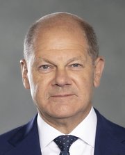 © Thomas Köhler_Bundesbildstelle Porträtfoto des Bundeskanzlers Olaf Scholz: Ein älterer Mann mit Halbglatze trägt einen Anzug mit Hemd und Krawatte.