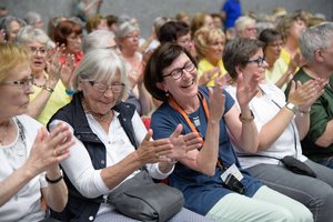 Blick in den Zuhörerraum. Zwei Frauen klatschen und lachen.