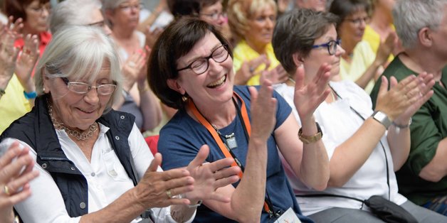 Blick in den Zuhörerraum. Zwei Frauen klatschen und lachen.