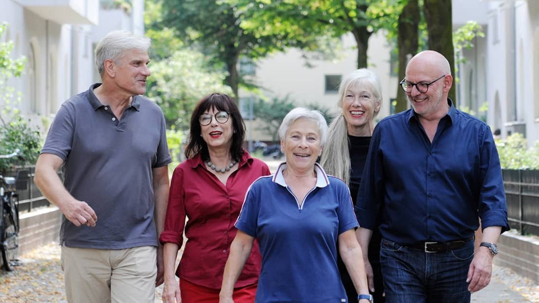 © contrastwerkstatt_adobe.stock.com Eine Gruppe älterer, fröhlicher Menschen kommen der Kamera entgegen