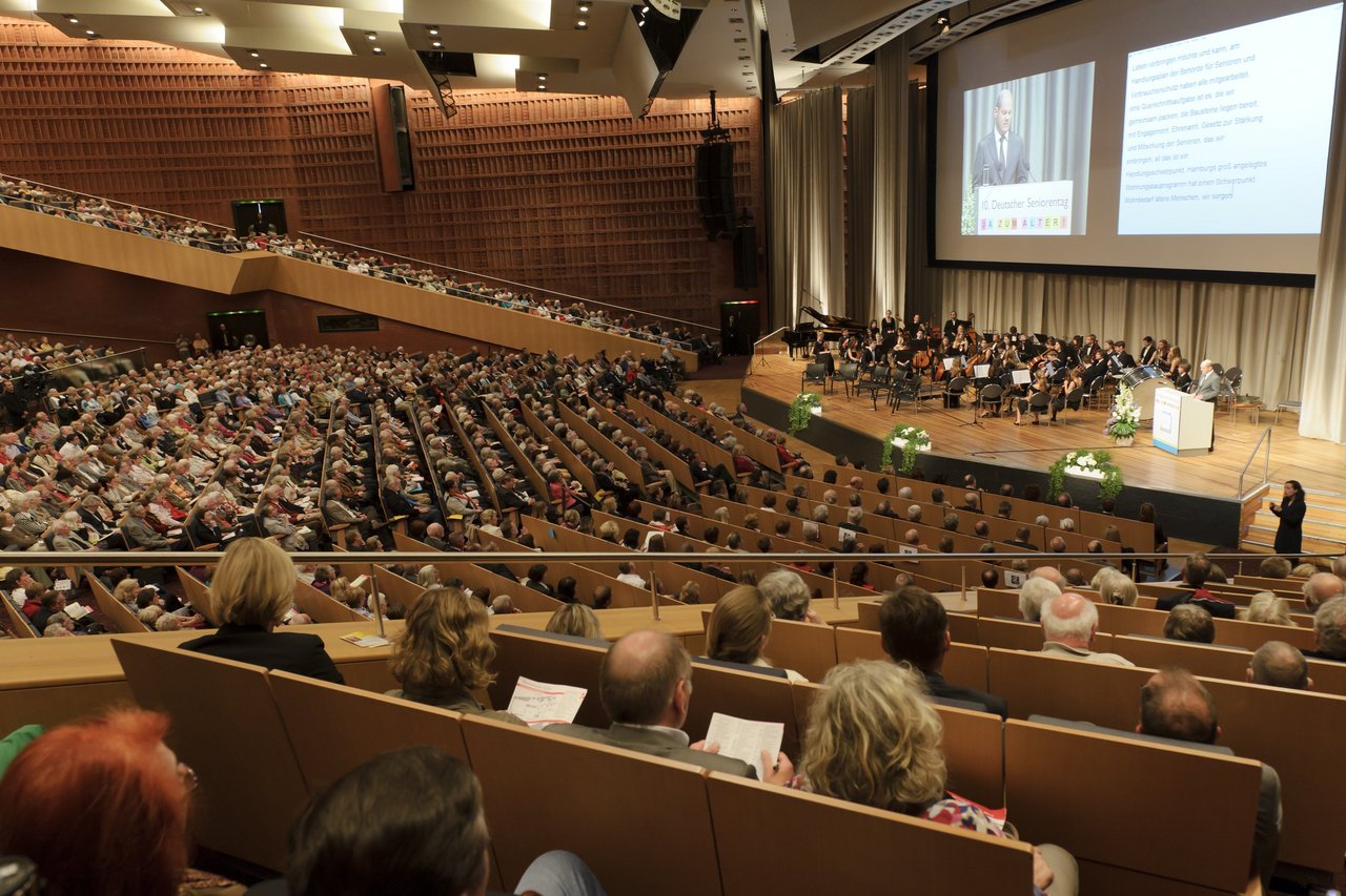 Publikum von hinten mit Blick auf Bühne