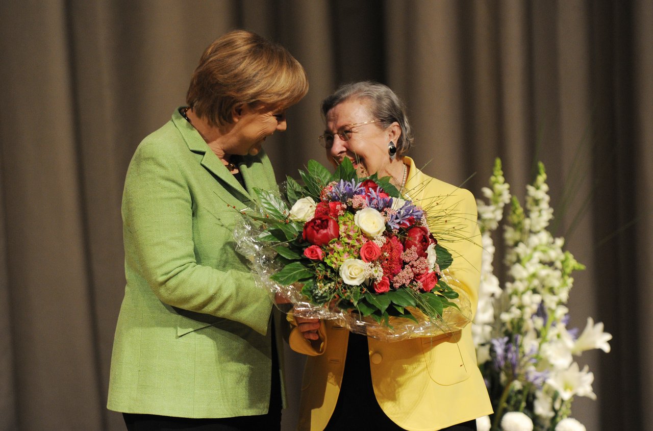 Ursula Lehr überreicht Angela Merkel einen Blumenstrauß