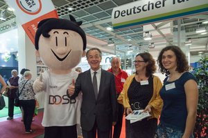 Franz Müntefering standing with the maskot of the German Olympic Sports Confederation an two women