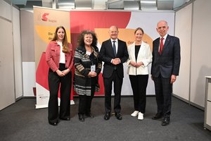 Gruppenfoto: Zwei junge Frauen, in schwarzen Hosen und Blazer, Charlotte Wilkens von AstraZeneca und Christina Claußen von Pfizer. Zwei ältere Männer mit kurzen Haaren und Halbglatze, Bundeskanzler Olaf Scholz und der stv. BAGSO-Vorsitzende Karl Michael Griffig. Ein ältere Frau mit sehr krausem dunklen Haar,  BAGSO-Vorsitzende Dr. Regina Görner.