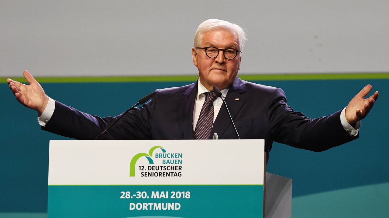 Frank-Walter Steinmeier am Rednerpult. Er breitet gerade die Arme aus.