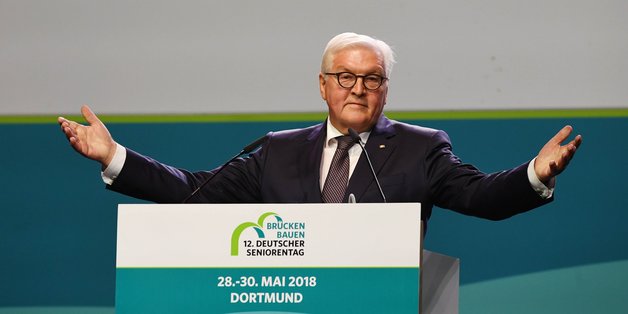 Frank-Walter Steinmeier am Rednerpult. Er breitet gerade die Arme aus.