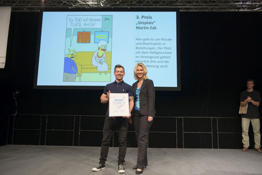 Manuela Schwesig übergibt einem Gewinner eine Urkunde beim Karikaturenwettbewerb